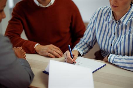 couple signing documents with a lawyer